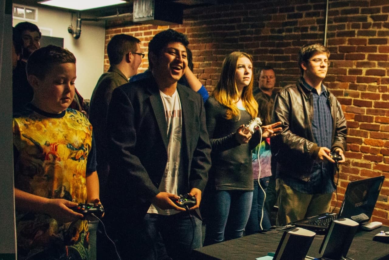 Teens enjoying locally made games at a showcase event hosted by Louisville Makes Games